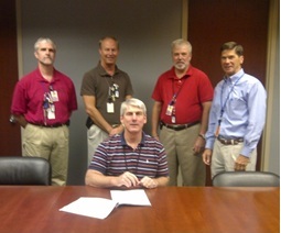 Callaway officials celebrate the signing of the Dry Storage contract: foreground: Mr. Cleve Reasoner, VP Engineering; from left to right: Mr. Steve Ewens, Project Manager; Mr. Shannon Abel, Manager, Major Projects; Mr. Tim Pettus, Supervisor, Major Projects; and Mr. Jay Skitt, Strategic Sourcing Analyst