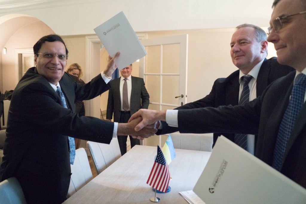 (From Left to Right in the Foreground) Dr. Kris Singh of Holtec, President Nedashkovsky of Energoatom, and General Director Subotin of Turboatom Clasp Hands to Mark the MOU Signing Event